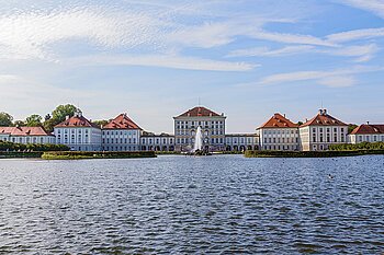 Zu sehen ist das Nymphenburger Schloss mit Wasser im Vordergrund